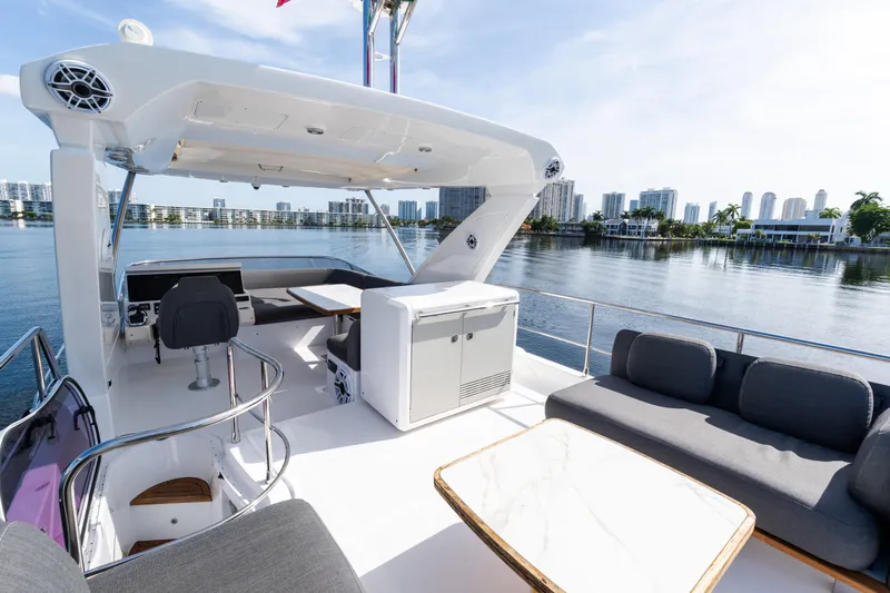 Andromeda Yacht Photos Pics Luxurious 2023 Azimut Fly 50 yacht deck with modern seating and scenic waterfront view.