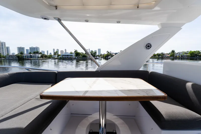 Andromeda Yacht Photos Pics 2023 Azimut Fly 50 yacht with elegant seating and table, overlooking waterfront skyline.