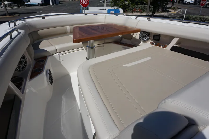 Bwce0015f324 Yacht Photos Pics 2024 Boston Whaler 350 Realm boat interior with cushioned seating and wooden table.