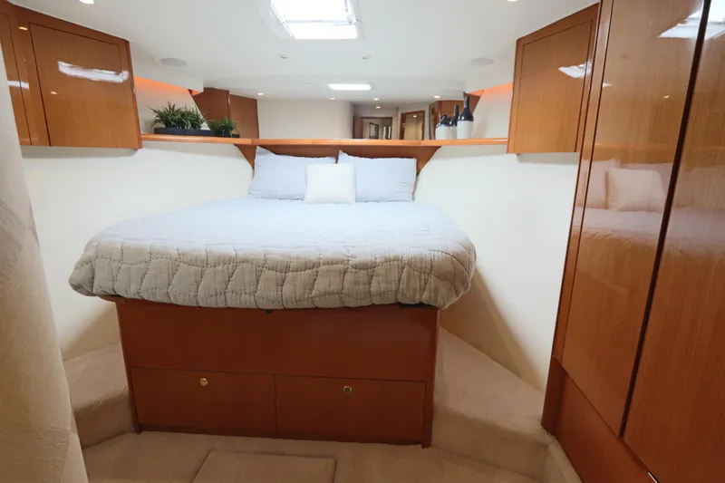 Angie Yacht Photos Pics Luxurious cabin interior of 2000 Viking 65 yacht with cozy bed and wooden cabinetry.