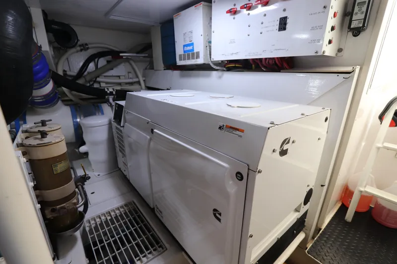 Angie Yacht Photos Pics Engine room of a 2000 Viking 65 yacht, featuring a Cummins generator and control panels.