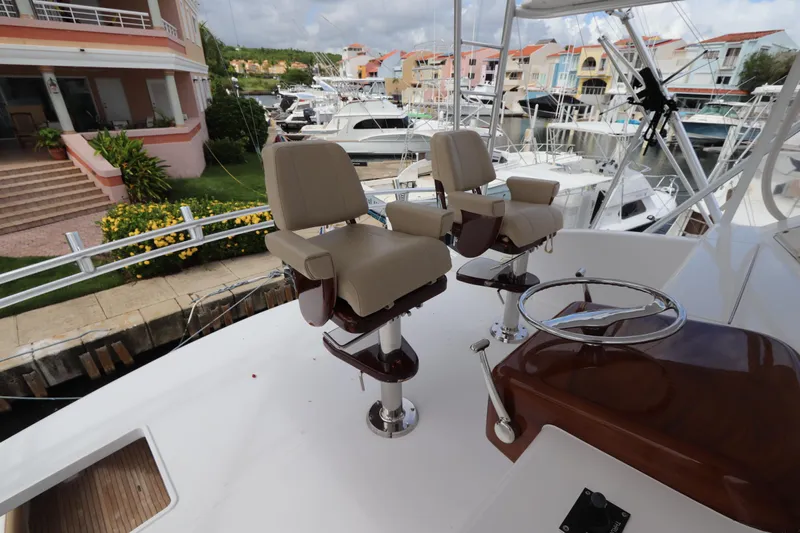 Angie Yacht Photos Pics 2000 Viking 65 yacht helm with dual captain chairs in marina setting.