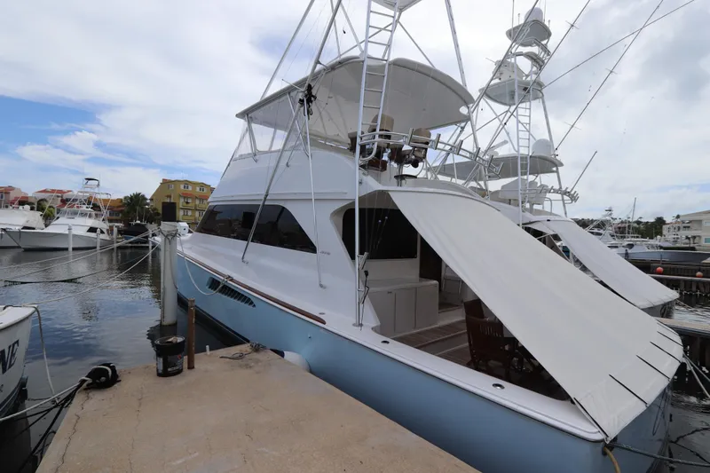 Angie Yacht Photos Pics Luxury Viking 65 yacht docked at marina, 2000 model, with sleek design and spacious deck.