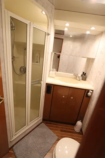 Angie Yacht Photos Pics Bathroom interior of a 2000 Viking 65 yacht with shower and wooden cabinetry.