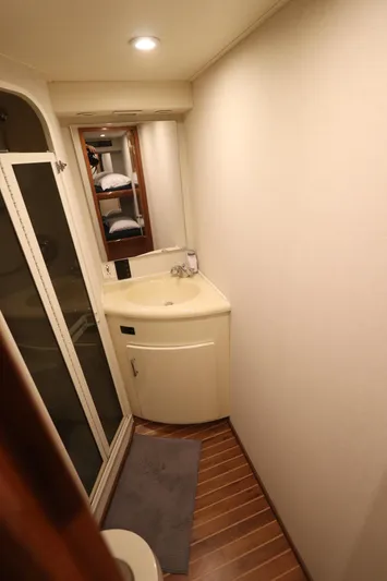 Angie Yacht Photos Pics Compact bathroom in a 2000 Viking 65 yacht with modern fixtures and wooden flooring.
