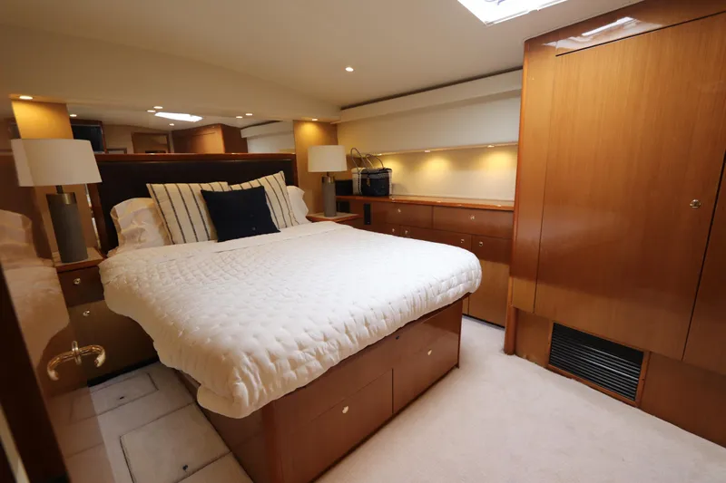 Angie Yacht Photos Pics Luxurious bedroom interior of a 2000 Viking 65 yacht with elegant wood finishes.