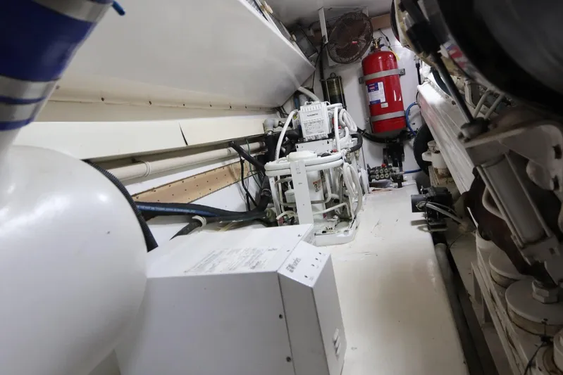 Angie Yacht Photos Pics Engine room of a 2000 Viking 65 yacht, featuring machinery and fire safety equipment.