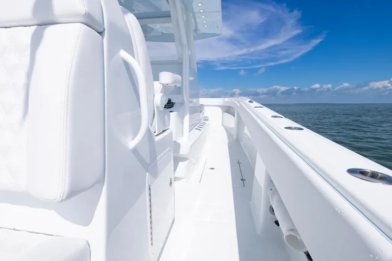  Yacht Photos Pics 2026 Invincible 33 Catamaran on open water, showcasing sleek white design and clear blue sky.