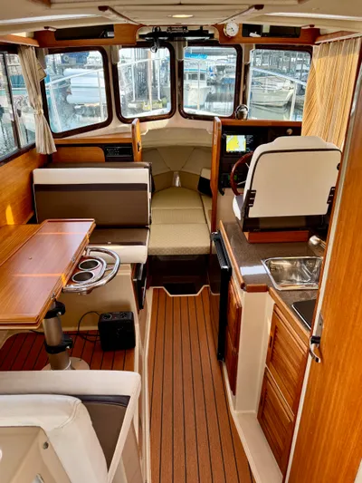 Lone Ranger Yacht Photos Pics 2017 Ranger Tugs Sedan interior with wood finish, dining area, and helm station.