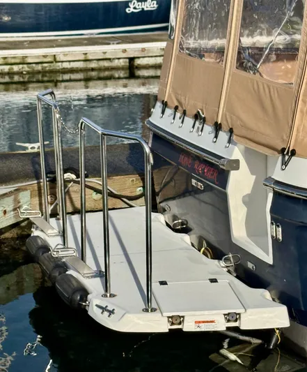 Lone Ranger Yacht Photos Pics 2017 Ranger Tugs Sedan boat docked with rear platform and railing.