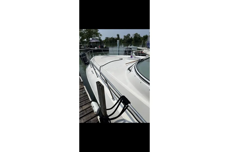  Yacht Photos Pics 2004 Cruisers Yachts 400 Express docked by a serene waterfront.