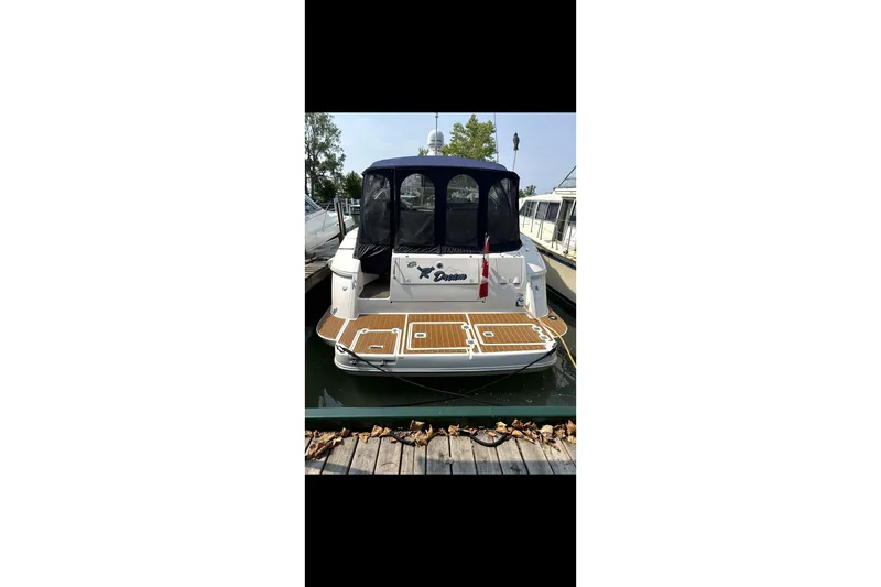  Yacht Photos Pics 2004 Cruisers Yachts 400 Express docked, rear view with canopy and Canadian flag.