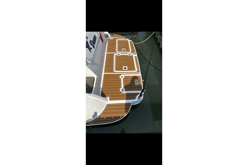  Yacht Photos Pics 2004 Cruisers Yachts 400 Express, teak deck detail, docked in calm water.