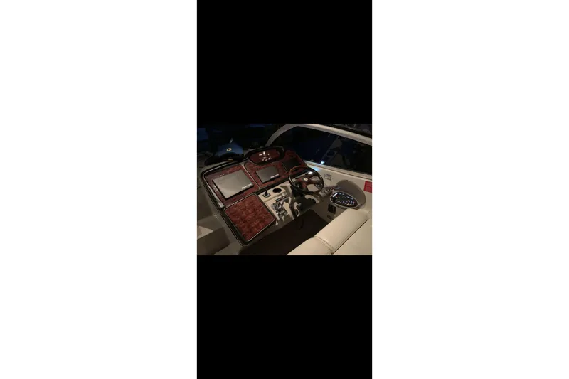  Yacht Photos Pics 2004 Cruisers Yachts 400 Express helm with modern navigation equipment and steering wheel.