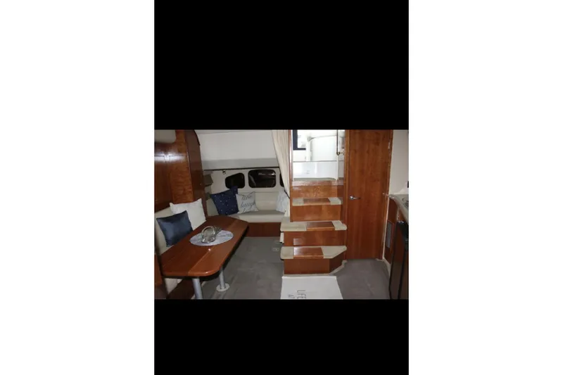  Yacht Photos Pics 2004 Cruisers Yachts 400 Express interior with wooden stairs and cozy seating area.