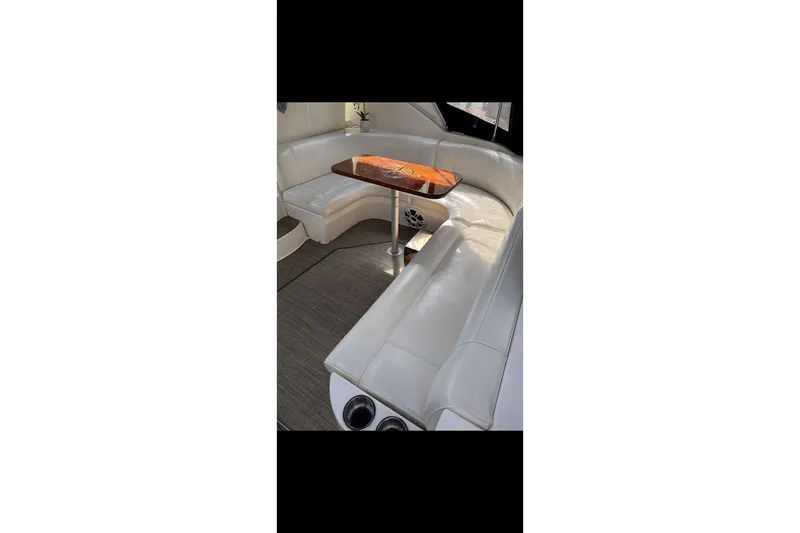  Yacht Photos Pics 2004 Cruisers Yachts 400 Express interior with white seating and wooden table.