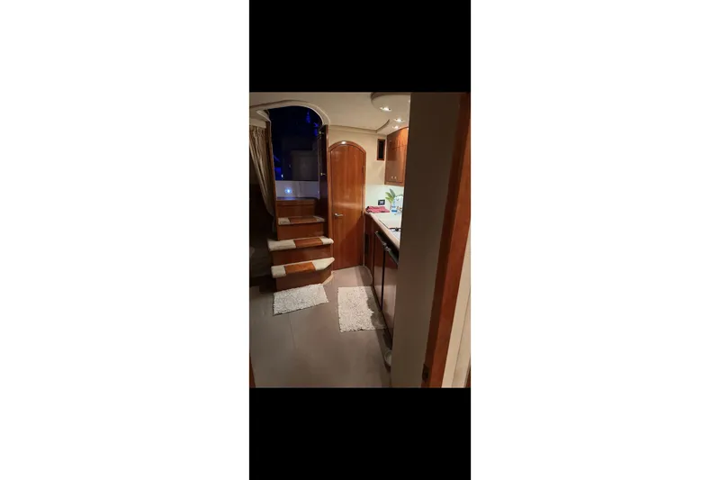  Yacht Photos Pics Interior of 2004 Cruisers Yachts 400 Express, featuring wooden stairs and modern kitchen area.