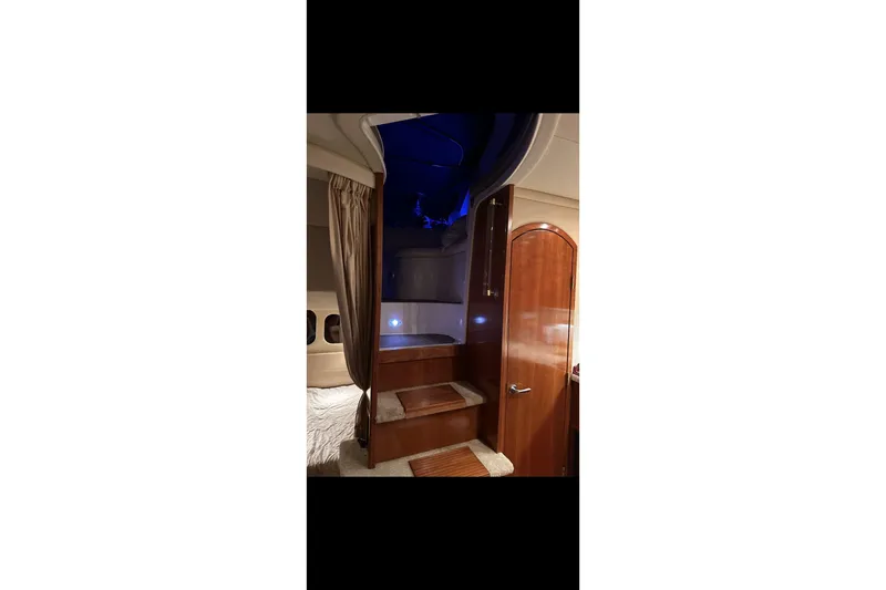  Yacht Photos Pics Interior of 2004 Cruisers Yachts 400 Express with wooden stairs and blue lighting.