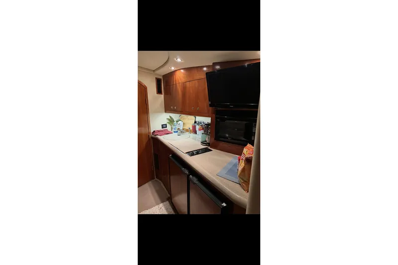  Yacht Photos Pics 2004 Cruisers Yachts 400 Express interior kitchen with modern amenities and wooden cabinetry.