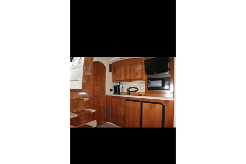  Yacht Photos Pics Interior of 2004 Cruisers Yachts 400 Express, featuring a compact kitchen with wood cabinetry.