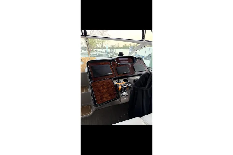  Yacht Photos Pics 2004 Cruisers Yachts 400 Express helm with navigation equipment and wood paneling.