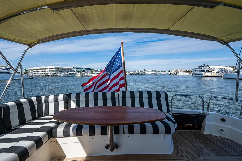 Captain And The Kid Yacht Photos Pics 2012 Sabre 48 Salon Express yacht with American flag, docked in marina.