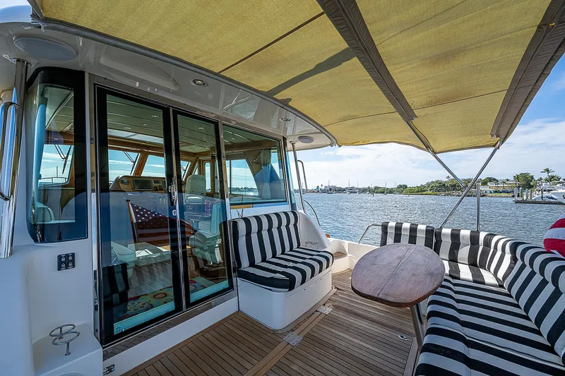 Captain And The Kid Yacht Photos Pics 2012 Sabre 48 Salon Express yacht with striped seating and wooden deck.