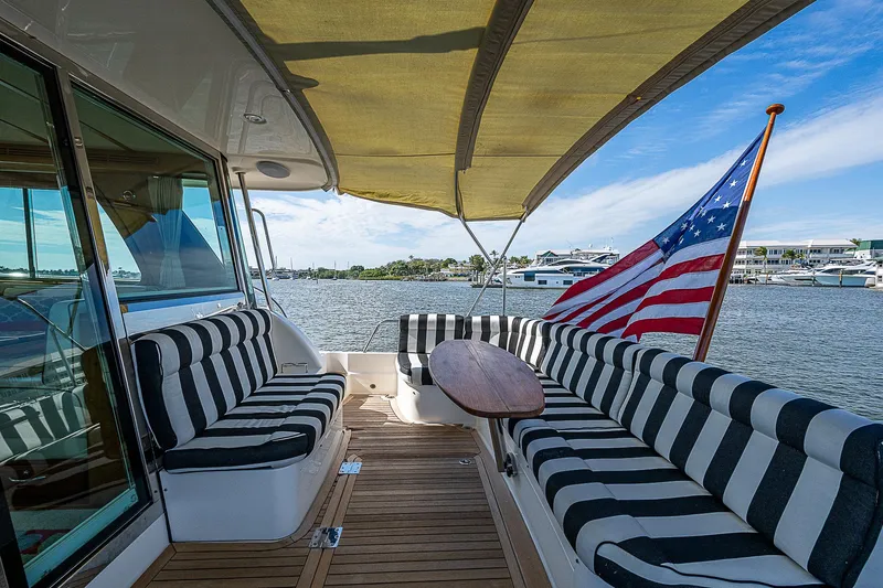Captain And The Kid Yacht Photos Pics 2012 Sabre 48 Salon Express yacht with striped seating and American flag on deck.