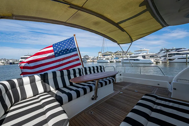 Captain And The Kid Yacht Photos Pics 2012 Sabre 48 Salon Express yacht with striped seating and American flag at marina.
