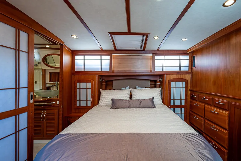 Captain And The Kid Yacht Photos Pics Luxurious bedroom interior of 2012 Sabre 48 Salon Express yacht with wooden cabinetry and modern design.