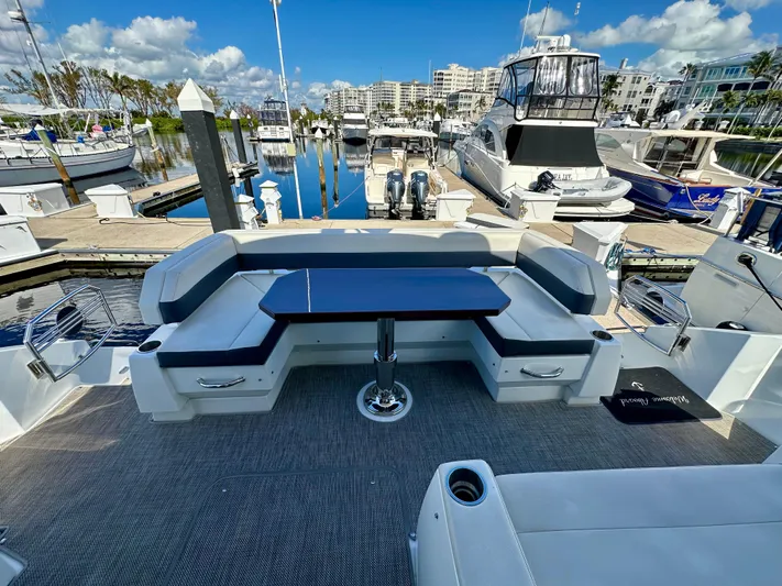  Yacht Photos Pics 2020 Cruisers Yachts 50 Cantius, spacious deck with seating, docked at marina.