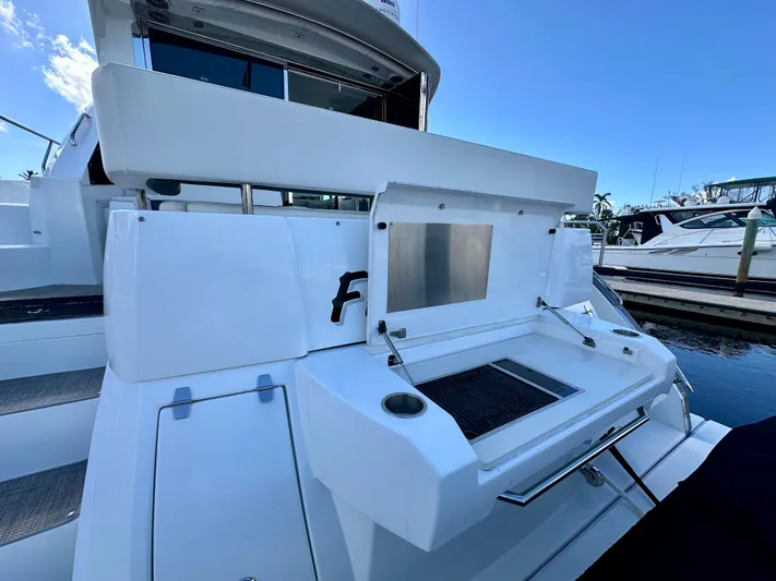  Yacht Photos Pics 2020 Cruisers Yachts 50 Cantius, rear deck view with open storage compartment.