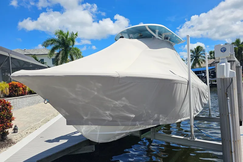  Yacht Photos Pics 2018 Tidewater 320 CC Adventure boat covered, docked under clear blue sky.