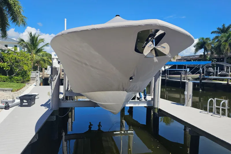  Yacht Photos Pics 2018 Tidewater 320 CC Adventure boat on lift, covered, in sunny marina setting.
