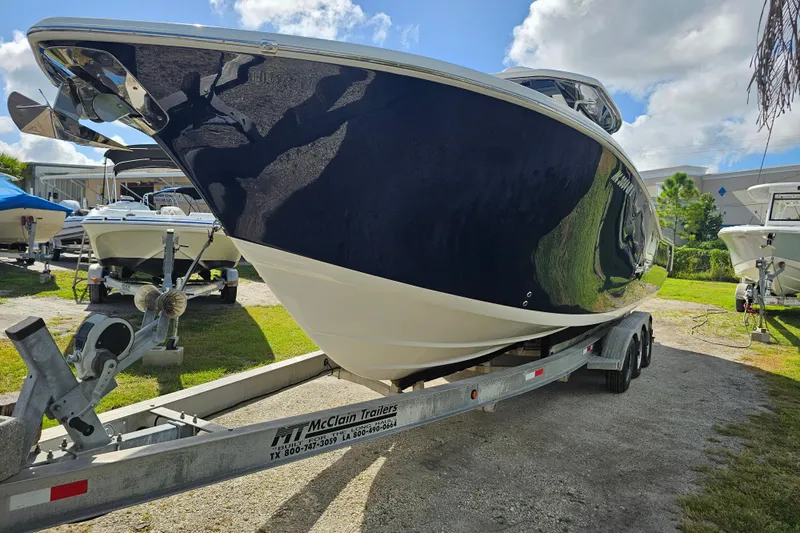  Yacht Photos Pics 2018 Tidewater 320 CC Adventure boat on trailer under sunny sky.