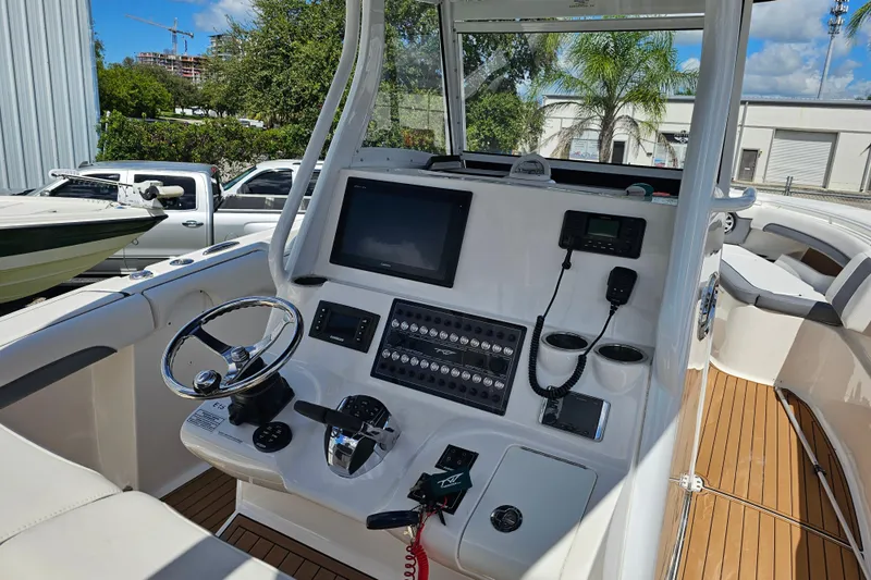  Yacht Photos Pics 2018 Tidewater 320 CC Adventure boat cockpit with steering wheel and control panel.