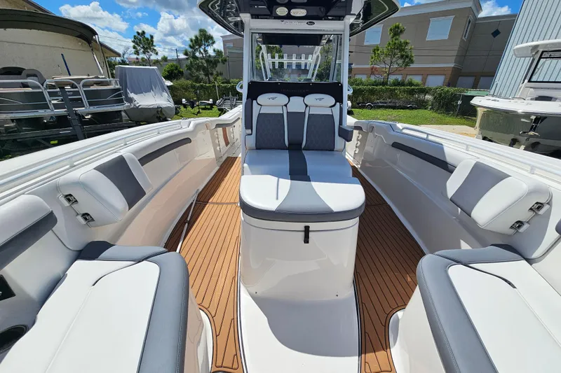  Yacht Photos Pics 2018 Tidewater 320 CC Adventure boat interior with cushioned seating and teak flooring.