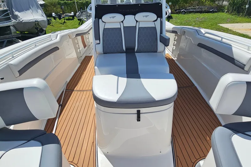  Yacht Photos Pics 2018 Tidewater 320 CC Adventure boat interior with cushioned seating and teak flooring.