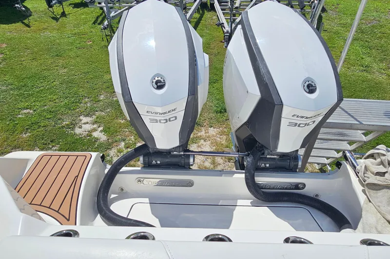  Yacht Photos Pics 2018 Tidewater 320 CC Adventure with dual Evinrude 300 engines, parked on grass.