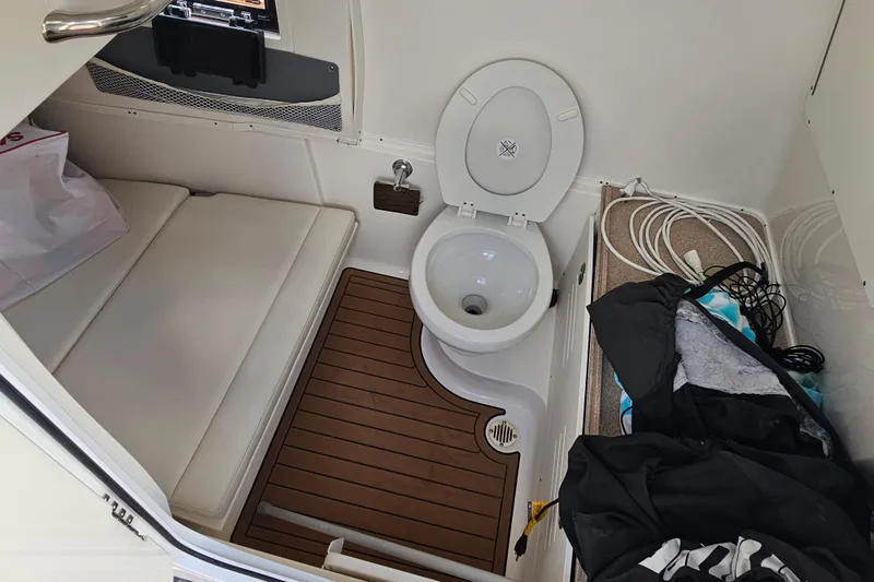  Yacht Photos Pics 2018 Tidewater 320 CC Adventure boat interior with toilet and seating area.
