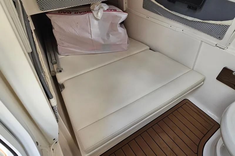  Yacht Photos Pics 2018 Tidewater 320 CC Adventure cabin interior with white cushions and storage bag.