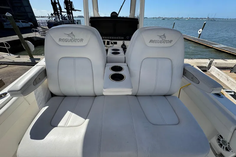  Yacht Photos Pics 2023 Regulator 31 boat seats with cup holders, docked by the water.