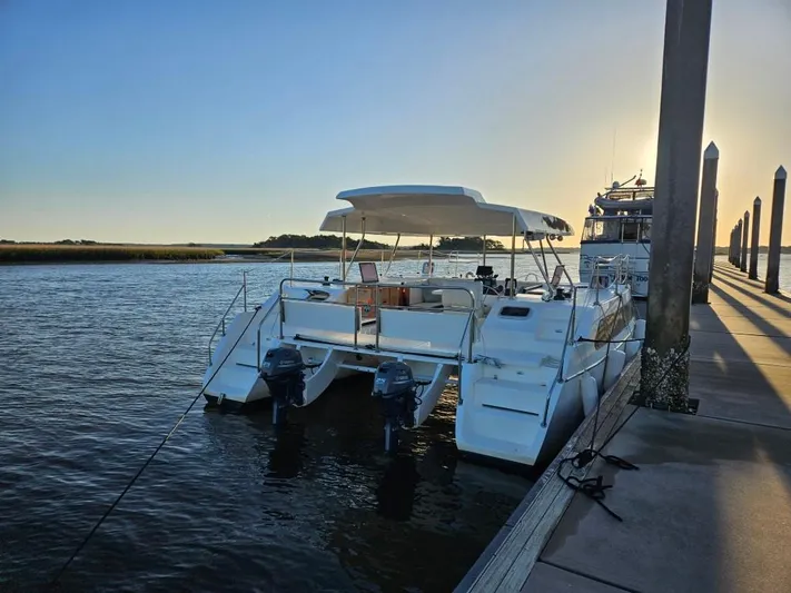  Yacht Photos Pics 2025 Smart Cat M280 Power catamaran docked at sunset, featuring dual outboard motors.