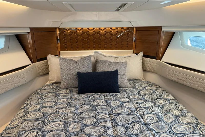  Yacht Photos Pics Luxurious cabin interior of 2025 Tiara Yachts 43 LE with elegant bedding and wood accents.