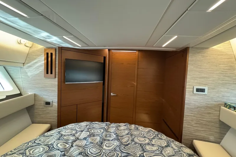  Yacht Photos Pics Luxurious interior of 2025 Tiara Yachts 43 LE with modern wood paneling and cozy bedding.
