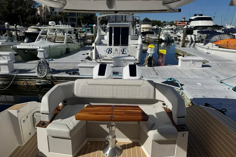  Yacht Photos Pics 2025 Tiara Yachts 43 LE at marina, featuring elegant seating and wooden table.
