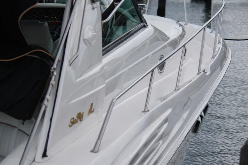 Knot Ez II Yacht Photos Pics 1998 Sea Ray 450 Sundancer yacht, white exterior, docked on calm water.