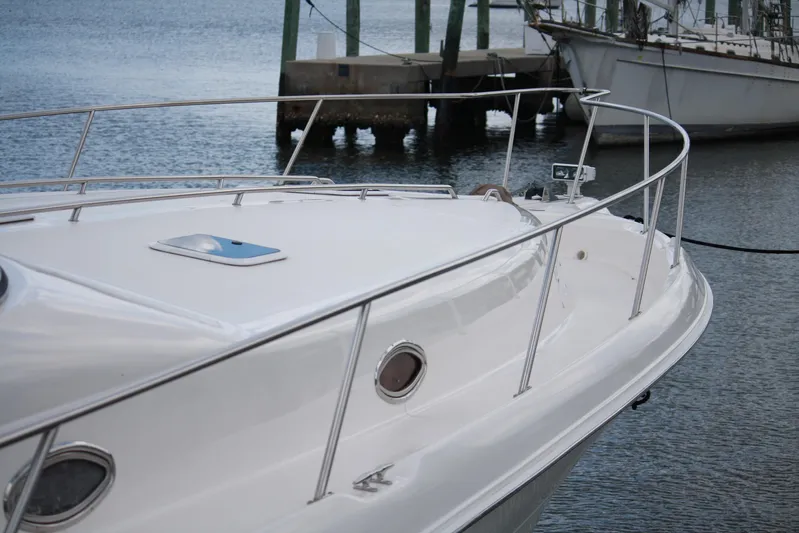 Knot Ez II Yacht Photos Pics 1998 Sea Ray 450 Sundancer yacht docked, showcasing sleek white deck and railing.