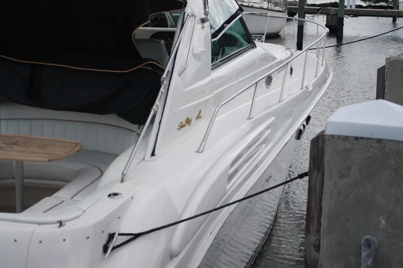 Knot Ez II Yacht Photos Pics 1998 Sea Ray 450 Sundancer yacht docked, featuring sleek white design and spacious seating area.