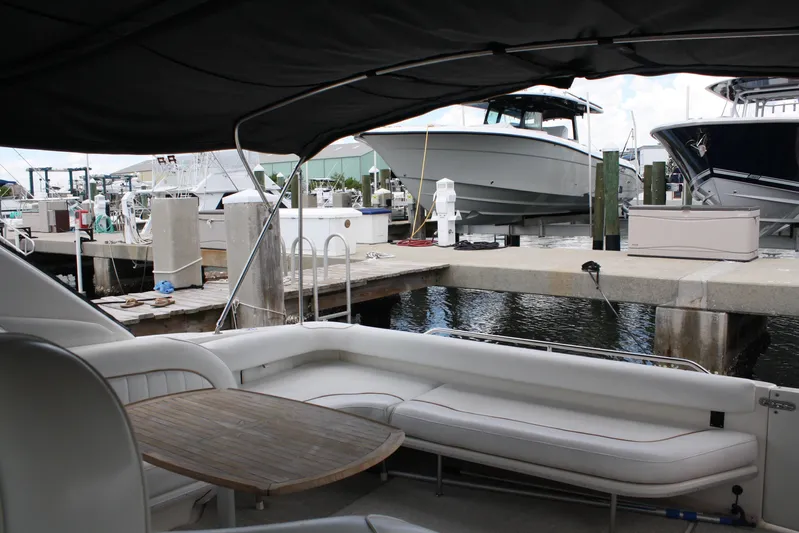 Knot Ez II Yacht Photos Pics 1998 Sea Ray 450 Sundancer yacht interior at marina, featuring seating and table.